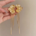 Dettaglio di orecchini a fiore dorati con nappe a catena e finiture in metallo lucido - Stile con perno dell'orecchino in argento / Oro