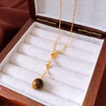 Macro shot of tiger eye pendant necklace on a wooden jewelry display with white velvet - 36# Necklace-Gold-Round