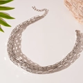 Detailed view of silver layered chain necklace with lobster clasp on a textured background - Silver