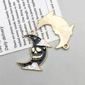 Gotische halve maan hanger met zwart emaille schedel en gouden rand op krant - Maanschedel