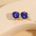 Macro shot of 14K gold plated earrings featuring cushion cut blue gemstones on stone base - Royal Blue (Gold)