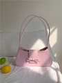 Pink minimalist baguette bag with bow detail and slim shoulder strap in a cozy setting - Pink