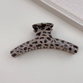 Dettaglio molletta per capelli leopardata beige e marrone su sfondo minimalista - Stile Appendiabiti Leopardo Chiaro