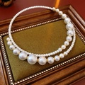 Detail of elegant double-layered pearl choker necklace with gold beads on vintage display - White/Gold