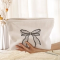 White corduroy cosmetic bag featuring black mesh bow embroidery and metal zipper detail - White Black Mesh Bow (WB210960)