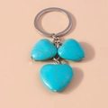 Dettaglio di tre ciondoli a forma di cuore in turchese con catena in metallo argentato - Cuore