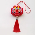 Détail macro du pendentif lion de danse chinoise rouge avec broderie et longue boucle en soie - Dragon de la Richesse / Rouge