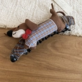 Detail view of a dachshund plush hair clip with blue plaid coat and red bowtie - Coffee-Blue