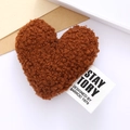 Detailed view of plush brown heart accessory featuring a white designer brand label - Coffee