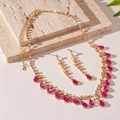 Detail shot of golden necklace and earrings set with pink drop-shaped gemstones and crystals - 2-Piece Necklace & Earrings Set / Rose Red Water Drop Style