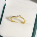 Nahaufnahme eines goldenen Schleifenrings mit Zirkonia-Besatz in einer Schmuckschatulle - Mikro-Pave Schleifen Stil (Gold 10)