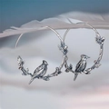 Vintage silver bird earrings with detailed leaves and berries on an artistic hoop design - Bird on Branch Hoop