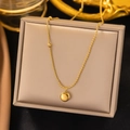 Goldene Lucky-Halskette mit graviertem Anhänger auf einer luxuriösen Schmuckschatulle - Perlenkette (Gold)