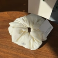 Close-up of cream-colored puff scrunchie with bow detail on a rustic wood surface - Cream White Bowknot Button Scrunchie