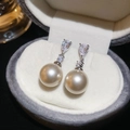 Elegant silver earrings with teardrop crystals and round pearls in a jewelry box - Gold