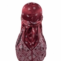 Detail of burgundy paisley silk durag with long tail straps on a white background - Wine Red Paisley