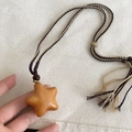 Ciondolo a stella in legno con cordino intrecciato marrone e nappa su collana sobria - Stella