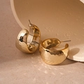 Macro detail of gold C-shaped wide hoop earrings with hammered textured metal surface - Steel Earring Post / Gold
