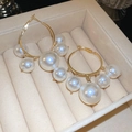 Detailed view of elegant gold hoop earrings with cascading white pearls in a jewelry box - 64# Silver Needle - Gold - White Pearls Of Various Sizes