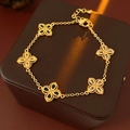 Macro shot of gold bracelet with colorful zircon clover charms on dark leather - Bracelet-Gold-Multicolor