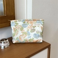 Floral jacquard fabric makeup bag with zipper closure on a wooden countertop - Flower Bud