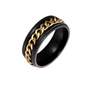 Close-up of black and gold stainless steel spinning ring with rotating chain detail - US 6