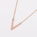 Macro view of rose gold V-shaped pendant necklace with sparkling micro-inlaid stones - Rose Gold