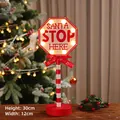 Segnale LED Santa Stop Here in legno da 30cm con asta a strisce rosse e luci calde natalizie - Ottagonale