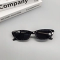 Vue détaillée de lunettes de soleil œil de chat rétro noires avec monture fine sur gris - Noir