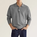 Macro shot of grey long-sleeve knit polo shirt showing textured fabric and three-button neckline - Gray