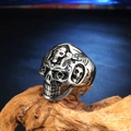Detailansicht eines Punk-Totenkopfrings mit Vintage-Oxidation auf Holzsockel - US 7 / Stahlfarbe