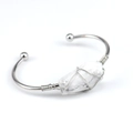 Macro detail of handmade wire wrapped white crystal stone on a metal open cuff bangle - Howlite