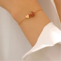 Collier doré avec pendentif basketball et cœur sur une chaîne fine porté par une femme - Bracelet de Basket-ball