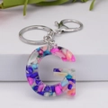 Macro detail of letter G resin keychain featuring colorful crushed stone inclusions - Letter G