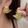 Gold ocean wave textured fan-shaped earrings worn by a model for a vintage look - Gold