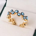 Detailed close-up of gold-plated evil eye ring with blue enamel in a white velvet box - Wrap-Around Multi-Eye Design (Style 7)