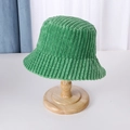 Detalle de la textura y costura del gorro bucket de pana verde en un soporte de madera - M (56-58cm) / Verde