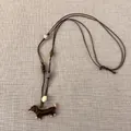 Detailansicht des braunen Dackel-Anhängers an einer handgewebten, verstellbaren Kordelkette - 14# Halskette - Braun Weiß - Dackel