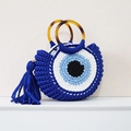 Vista de detalle del bolso de punto ojo turco con asas de carey y adornos de borlas - Azul con borla
