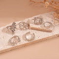 Dettaglio di sei anelli in metallo argentato con conchiglia e stella marina su pietra - Argento (Set di 6)