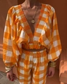 Detail of orange gingham two-piece set featuring a deep V-neck crop top and high waist pants - Orange