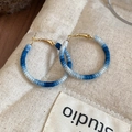 Gros plan de boucles d'oreilles créoles rondes avec fil de coton tressé dégradé bleu - Style Créoles en Coton Tissé Dégradé Bleu