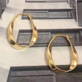 Polished golden twist hoop earrings with a stylish minimalist textured design - Twisted Hoop / Gold