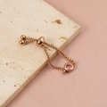Detail showing pink birthstone and rose gold adjustable slider mechanism for the ring - Rose Gold