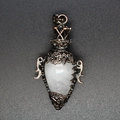 Détail d'un pendentif en cuivre vintage ajouré orné d'une pierre en cristal blanc - Cristal de roche