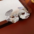Macro shot of silver metal hoop earrings with elegant shell texture and wavy pattern - Silver Earring Post Style / Silver
