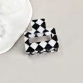 Close-up of black and white checkerboard hair claw clip on a stylish decorative tray - Black/White 5cm Diamond Grid