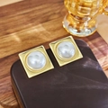 Elegant gold square stud earrings with large white pearls on a vintage brown leather base - #5 Pearl Square Stud Earrings