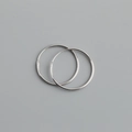 Macro shot of polished S925 sterling silver hoop earrings with classic clasp detail - 24mm / White Gold