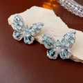 Detailed macro view of silver butterfly earrings with blue zircon and pearls - Light Blue Butterfly Zircon Stud Earrings